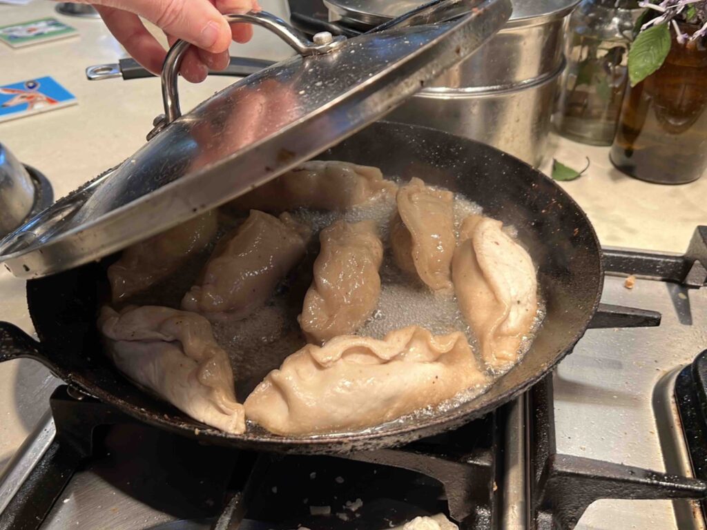 Dumplings cooking with a lid on