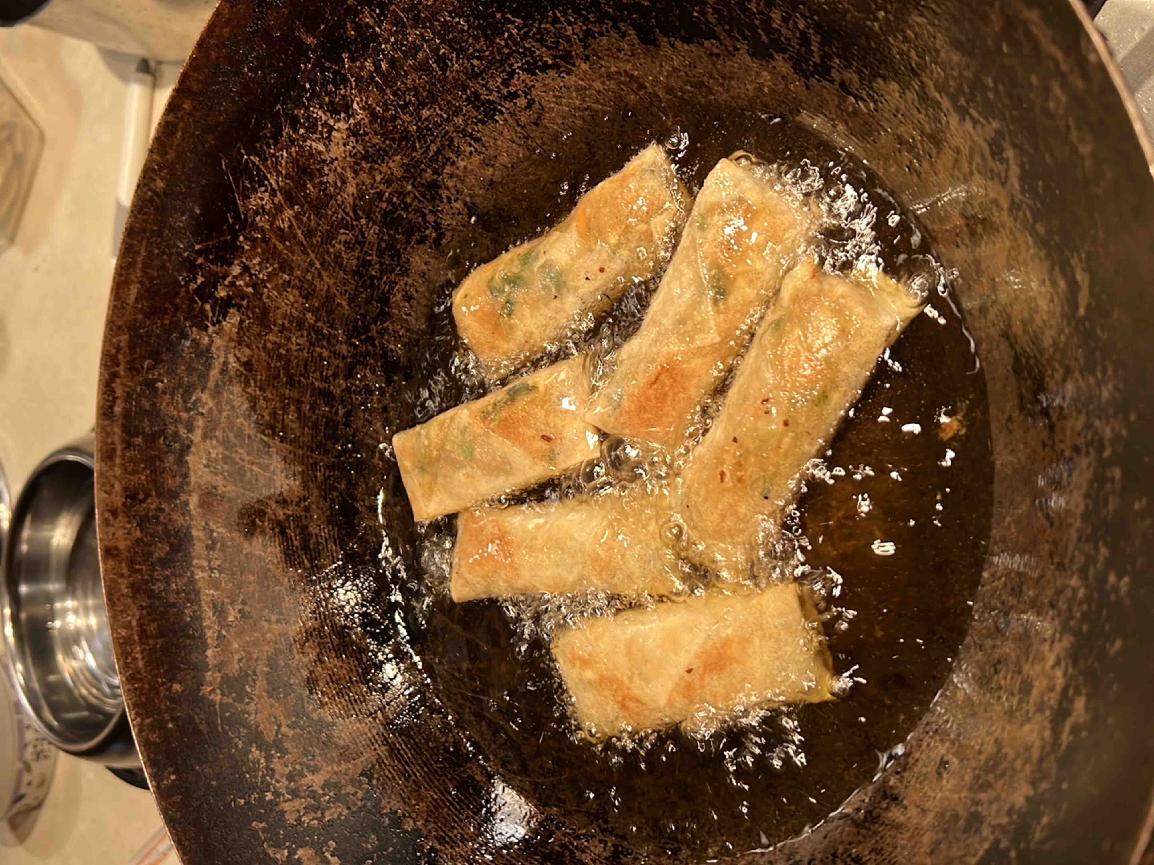 Spring rolls cooking in a wok