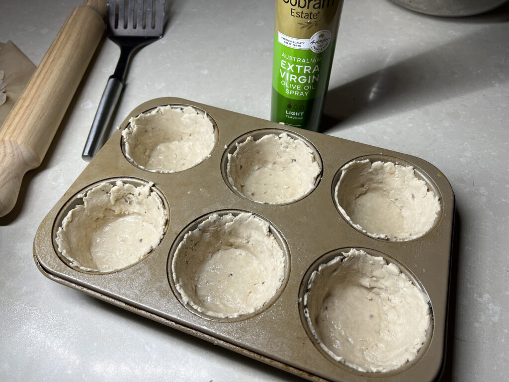 Pastry pushed into muffin tray
